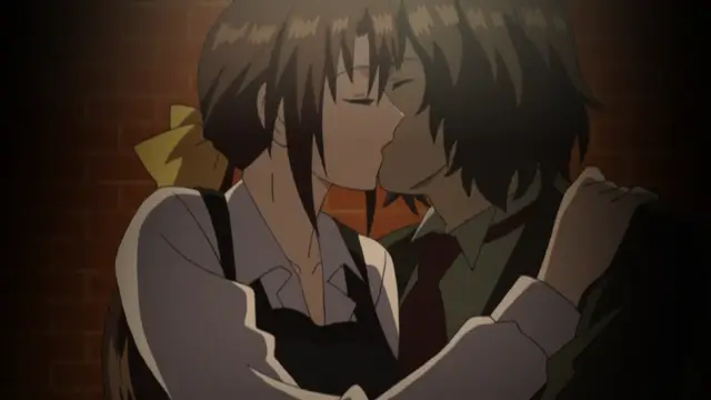 A girl in a school uniform and a boy in a school uniform are shown kissing each other against a brick wall. Screenshot from Kara no Shoujo - Episode 1