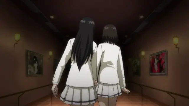 Two schoolgirls with long dark hair, wearing white blazers and pleated skirts, walk side by side down a dimly lit hallway decorated with gold-rimmed paintings and wall sconces. Screenshot from Kara no Shoujo - Episode 2
