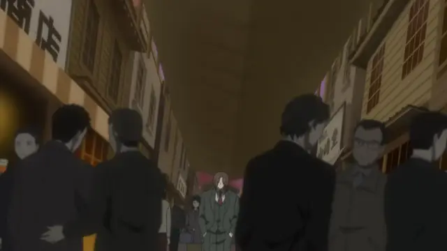 A woman in a green uniform stands in a crowded Japanese street filled with buildings and people. Screenshot from Kara no Shoujo - Episode 2
