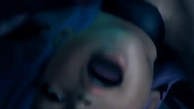 An extreme close-up of a woman's face with heavy makeup and closed eyes, showing her blushing expression as she lies down against a blue background. Screenshot from Kunoichi 3: Dark Butterfly