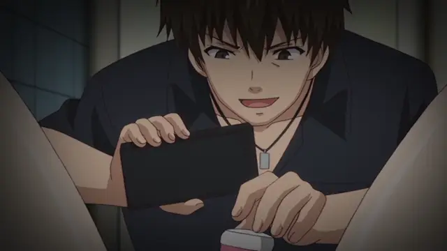 A young man with dark hair and a slight smirk watches a video on his smartphone while sitting in a room, looking secretly at the screen from between two large objects. Screenshot from Ore ga Kanojo o ***su Wake - Episode 3
