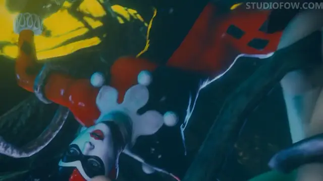 An anime woman dressed in a red and white harlequin-style outfit with white facial markings and large ruffles looks upward with an expression of pleasure while being penetrated from behind in a dimly lit room. Screenshot from Tentacle Trouble