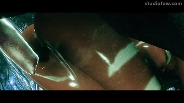 A close-up, low-angle shot shows a large, erect penis with prominent veins and a glistening sheen of cum dripping down a woman's wet, tanned thighs as they are pressed against each other in a dark, dimly lit setting. Screenshot from The Circle Of Life