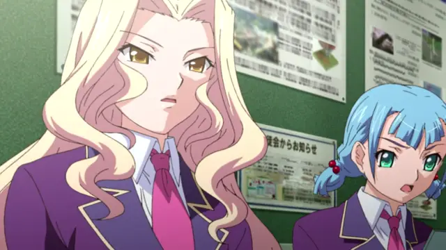 A tall blonde woman with a stern expression and a blue-haired girl with a worried look stand side-by-side in school uniforms in front of a bulletin board. Screenshot from Saimin Ryoujoku Gakuen - Episode 1
