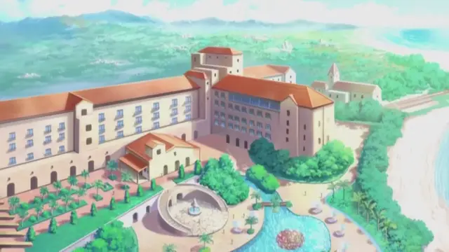 A wide, high-angle shot of a large Mediterranean-style resort hotel with red roofs and arched windows, situated next to a beach and surrounded by lush tropical landscaping and palm trees. Screenshot from Nee Summer! - Episode 2