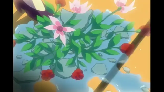 A high-angle shot shows a cluster of green leaves and pink and red flowers growing around rocks in a small pond of clear blue water. Screenshot from Elfina: Yoru e to Urareta Oukoku de... - Episode 2