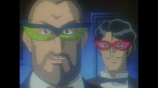 Two men wearing superhero masks, one with green goggles and the other with red goggles, stand side by side in a dimly lit room. Screenshot from Imma Youjo: The Erotic Temptress - Episode 5