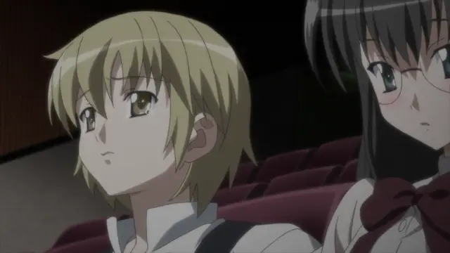 A blonde-haired anime girl with tears in her eyes sits next to a brunette girl with glasses in a theater-like setting. Screenshot from Aki Sora: In a Dream - Episode 2