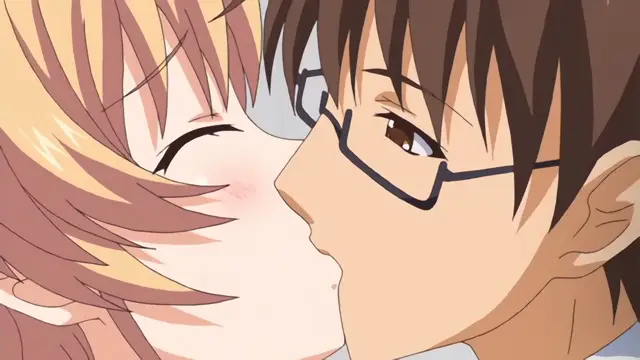 A close-up anime-style shot shows a brown-haired boy with glasses leaning in to kiss a blonde girl with closed eyes and blushing cheeks. Screenshot from Nuki Doki Tenshi to Akuma Battle - Episode 2