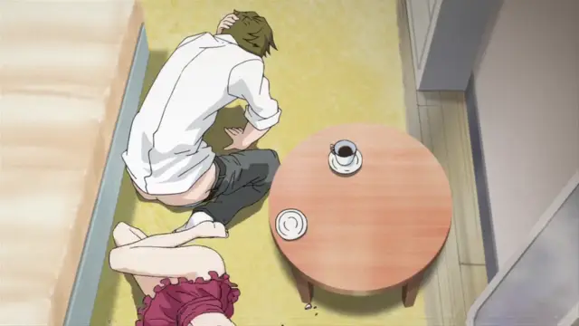 From a high-angle perspective, a man in a white shirt and dark pants sits on the floor next to a woman in a pink ruffled outfit, both looking down at a low coffee table with two cups, in a scene that implies a sexual encounter. Screenshot from Nozoki Ana