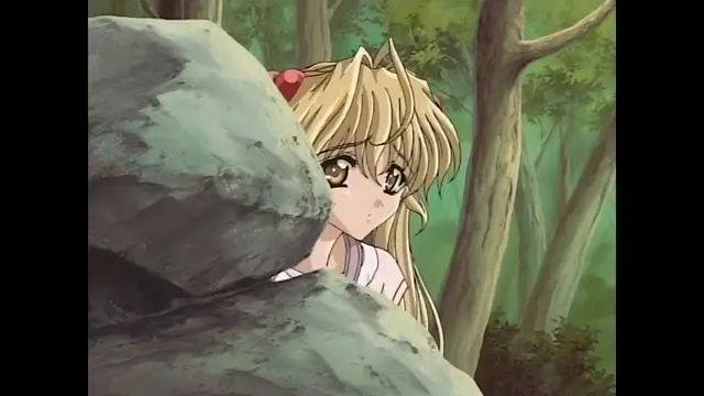 A blonde anime girl with long hair and a red hairband peeks out from behind a large grey rock in a lush forest. Screenshot from Moonlight Lady - Episode 1