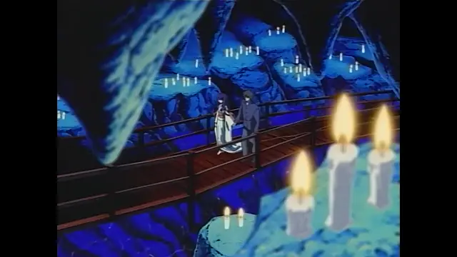 A woman in a white dress kneels on a wooden bridge in a glowing blue cave, while a man in a suit stands over her and holds her hand, surrounded by many lit candles. Screenshot from Moonlight Lady - Episode 4