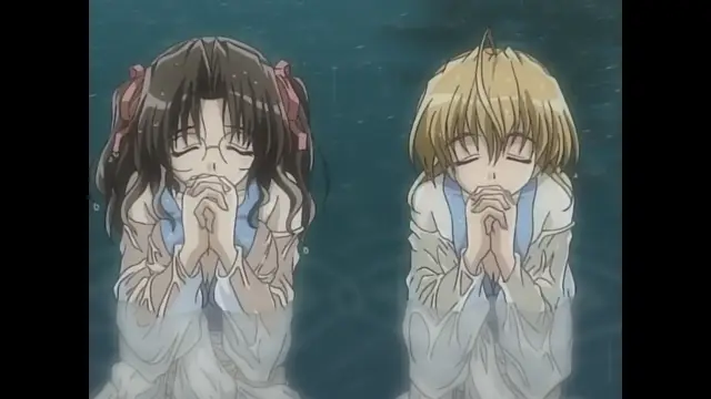 A girl with long dark hair and a boy with blonde hair stand side by side in a pool, wearing white clothes and closing their eyes in prayer with their hands pressed together. Screenshot from Moonlight Lady - Episode 5