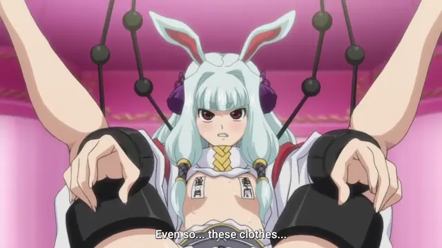 An anime girl with white hair and bunny ears is tied up with ropes and bound to a bed in a suggestive pose, wearing a revealing white and gold outfit with the subtitles "Even so... these clothes...". Screenshot from Aku no Onna Kanbu - Episode 2