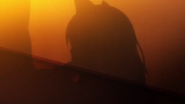 A silhouette of an anime girl with long hair and cat ears sits on a floor against a glowing orange and yellow background, looking towards the left. Screenshot from Akane wa Tsumare Somerareru - Episode 1