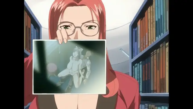 A red-haired woman wearing glasses holds up a photo in a library that depicts a woman being penetrated from behind by another woman. Screenshot from Cleavage - Episode 2