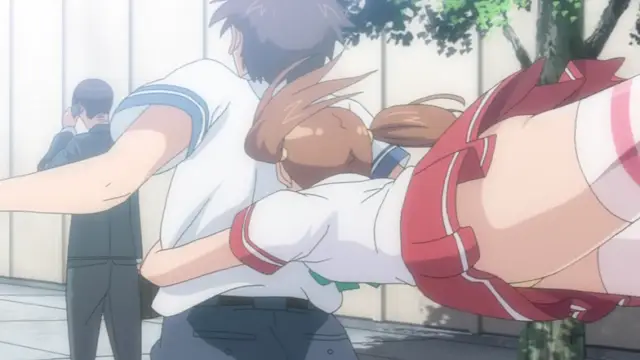 A girl in a school uniform with red and white details is being held horizontally by a boy in a white shirt while she is bent over his waist in an outdoor school setting. Screenshot from Otome Dori - Episode 1