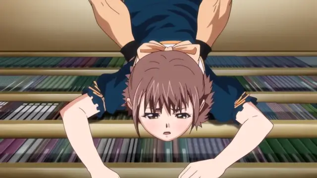A blush-faced girl with brown hair and a ribbon in her hair lies face-down on a bookshelf, looking up with an embarrassed expression. Screenshot from Diabolus Kikoku - Episode 2