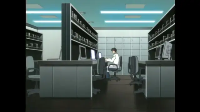A man sits alone in a dimly lit office with multiple computer monitors, typing on a keyboard at a desk surrounded by file cabinets and shelves. Screenshot from Cambrian - Episode 1