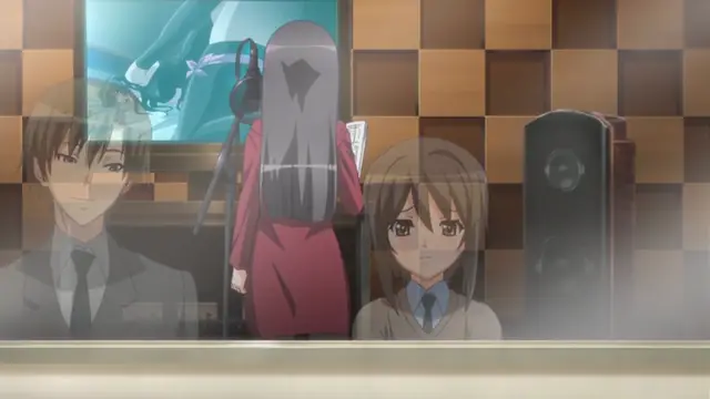 A high school girl and an anime man sit in a classroom next to a woman in a red dress who is standing with her back turned towards the camera. Screenshot from Yume Kui: Tsurumiku Shiki Game Seisaku - Episode 1