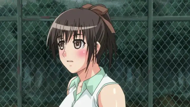 A blushing anime girl with dark hair in a brown ribbon and a white sleeveless shirt looks shocked or embarrassed while standing in front of a chain-link fence. Screenshot from Fault!! - Episode 1