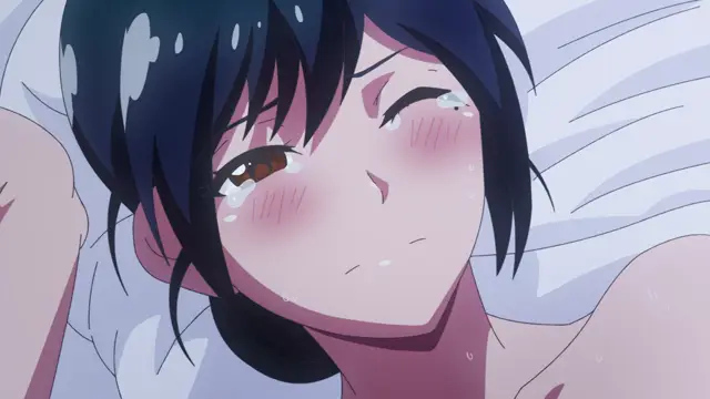 An anime girl with dark blue hair and blushing cheeks lies on a white bed with a dazed, sweaty expression and one eye closed. Screenshot from Kimi ga Suki - Episode 1