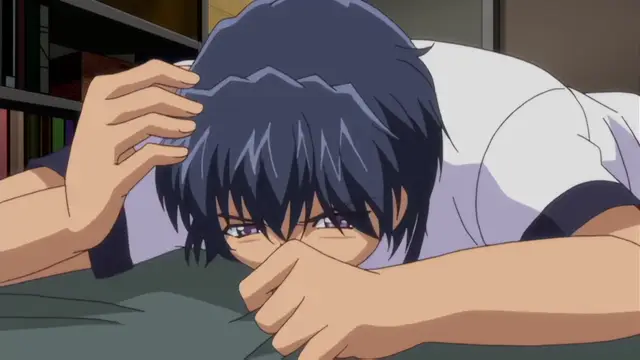 A blue-haired anime man lies face down on a bed with his hands over his face and his eyes partially open, looking distressed or exhausted. Screenshot from Otome Chibaku Yuugi - Episode 1