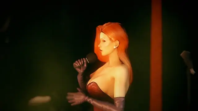 A woman with long orange hair and a red strapless dress holds a microphone and performs on a dark stage under a spotlight. Screenshot from Songbird's Shame