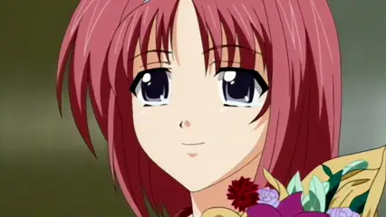 A close-up anime-style illustration of a girl with red hair, blue eyes, and a small blue bow, smiling while wearing a yellow kimono decorated with large purple and pink flowers. Screenshot from Futari no Aniyome - Episode 2